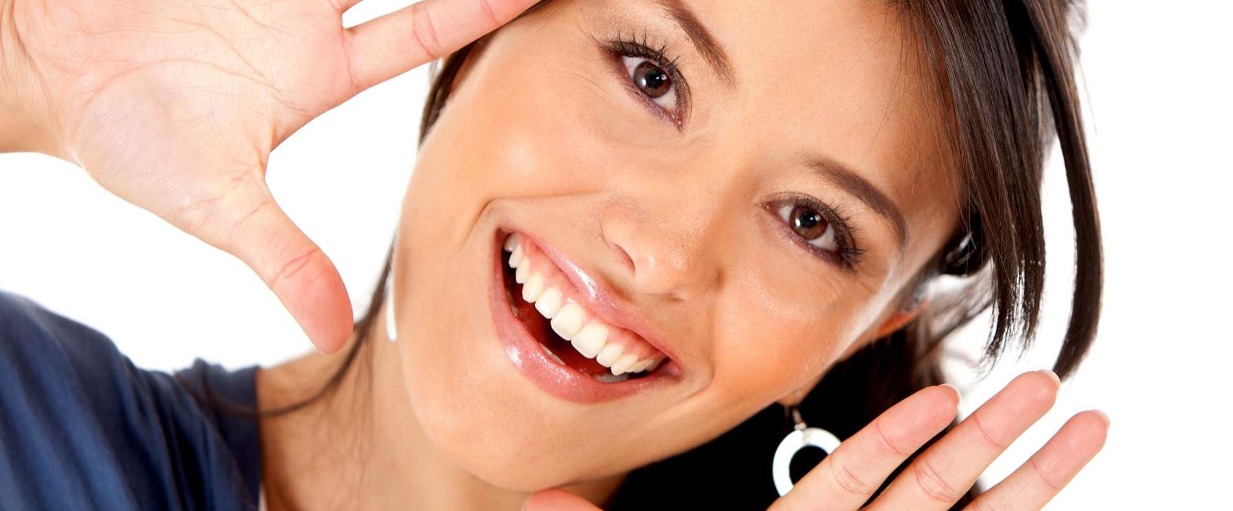 Smiling woman gesturing proudly, showing off her Invisalign results.