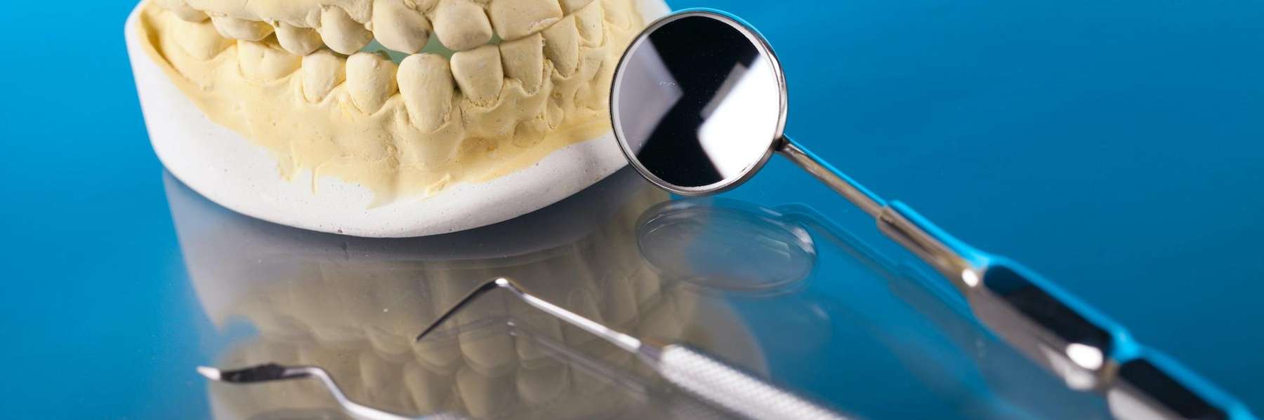 Close-up of dental tools, including a mirror and teeth model, used during emergency dental care