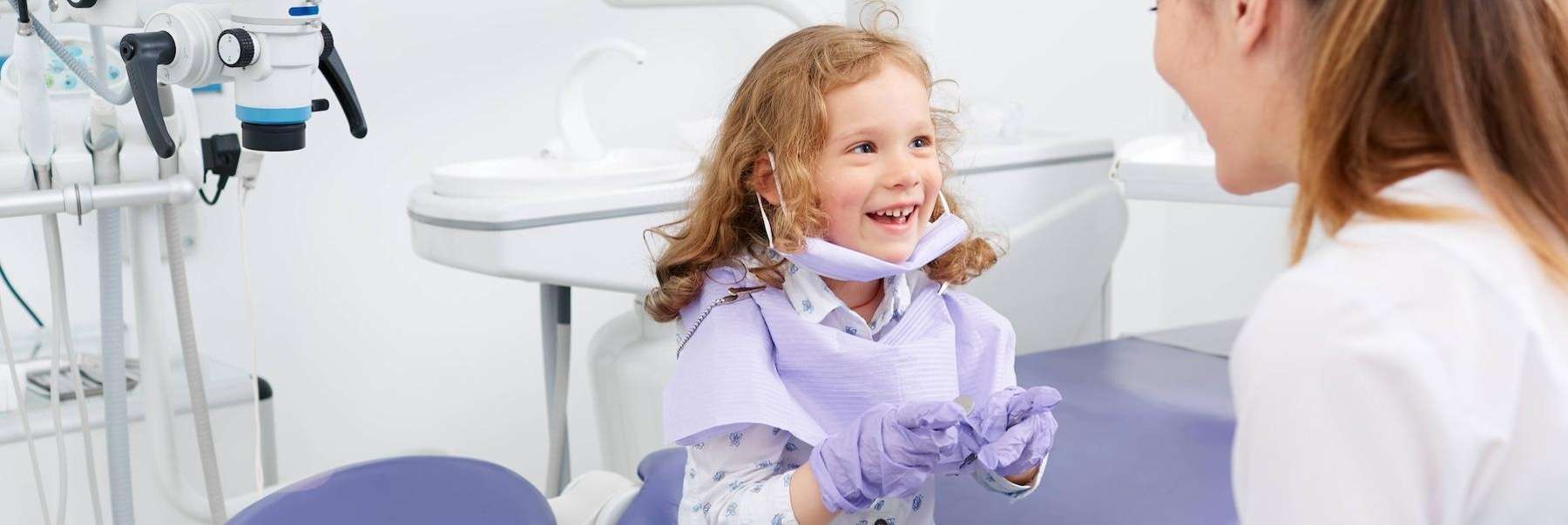 A kid smiling brightly at a dentist
